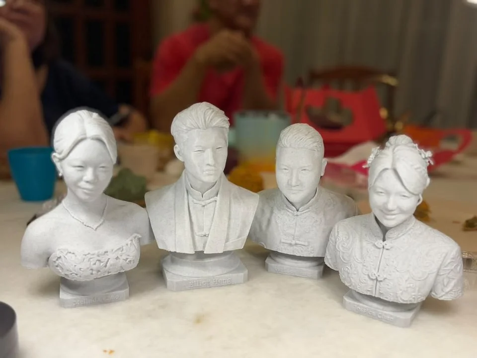 Four marble statue caricatures lined up on a table